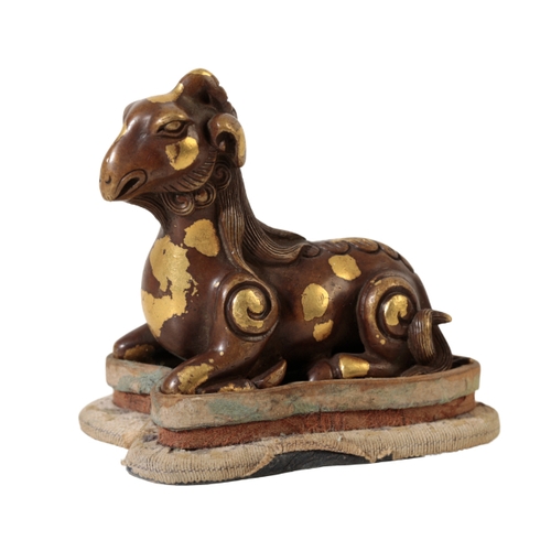 79 - A CHINESE BRONZE SCROLL-WEIGHT modelled as a recumbent goat with well defined mane and curly tail an... 