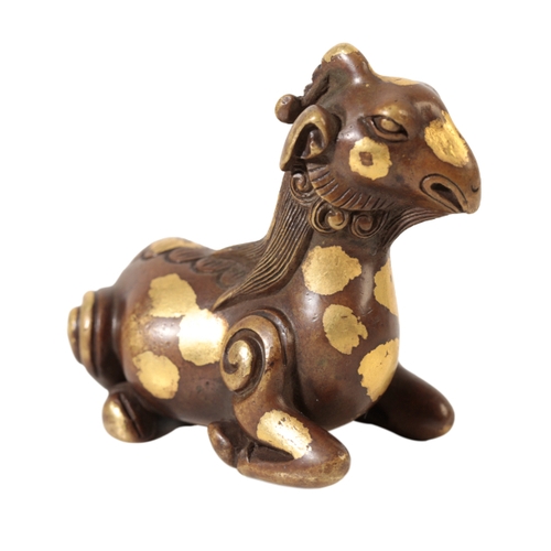 79 - A CHINESE BRONZE SCROLL-WEIGHT modelled as a recumbent goat with well defined mane and curly tail an... 