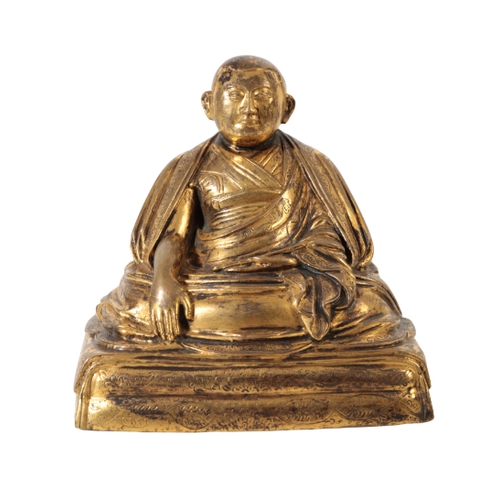 80 - A CHINESE GILT BRONZE OF A MONK seated cross legged beneath flowing robes, on a square ' cushion' ba... 