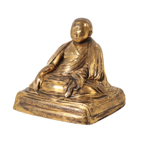 80 - A CHINESE GILT BRONZE OF A MONK seated cross legged beneath flowing robes, on a square ' cushion' ba... 