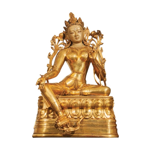 81 - A MONUMENTAL SINO-TIBETAN GILT BRONZE OF TARA, QING wearing an elaborate headdress and seated on a l... 