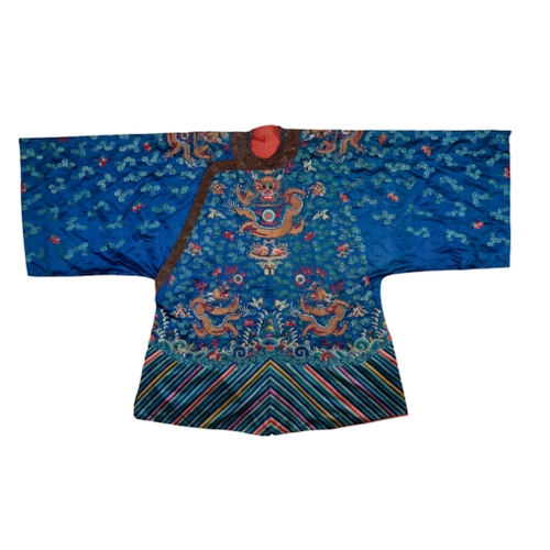 86 - A CHINESE BLUE SILK DRAGON ROBE embroidered in colourful silks with five- clawed dragons, birds and ... 