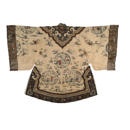 87 - A CHINESE IVORY SILK SHORT ROBE embroidered with figures in roundels and landscape vignettes within ... 