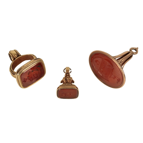 187 - A 19TH CENTURY CARNELIAN FOB SEAL the intaglio with engraved crest, together with two other similar ... 