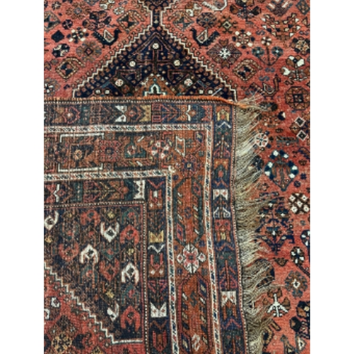 219 - A NORTH WEST PERSIAN CARPET early 20th century, the brick red ground with four central medallions, w... 