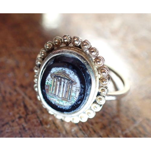 357 - A GRAND TOUR MICRO MOSAIC RING depicting ancient ruins, with a high carat gold cannetille surround a... 