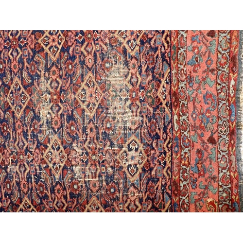 614 - A NORTH-WEST PERSIAN BIDJAR RUG, HERATI FIELD with red borders, 238 x 206cms (wear, fraying)