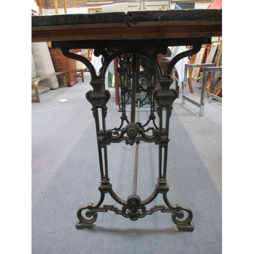 689 - A REFECTORY STYLE TABLE WITH CAST IRON BASE and black painted pine boarded top 197 x 72cm, 75cm high