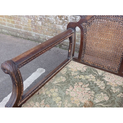 710 - A 1920S BERGERE THREE-PIECE SUITE the mahogany frame carved with bird's heads, bellflower, and scrol... 