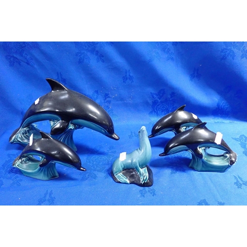 284 - FOUR POOLE POTTERY DOLPHINS with a Poole Pottery seal (chipped)