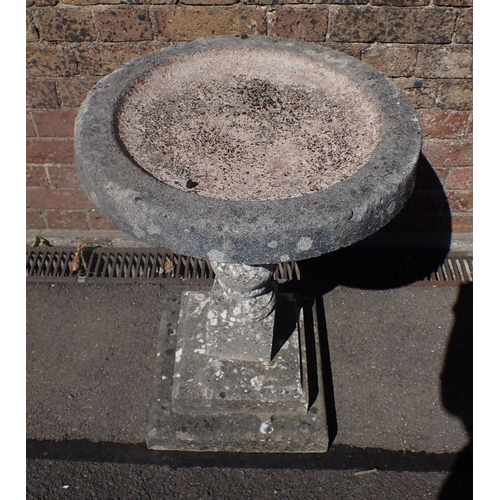 10 - A RECONSTITUTED STONE BIRD BATH 67cm high, 47cm diam.