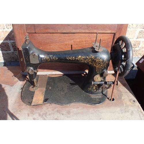 120 - A WILCOX & GIBBS SEWING MACHINE cased, two treadle sewing machines, and an iron treadle base (all fo... 