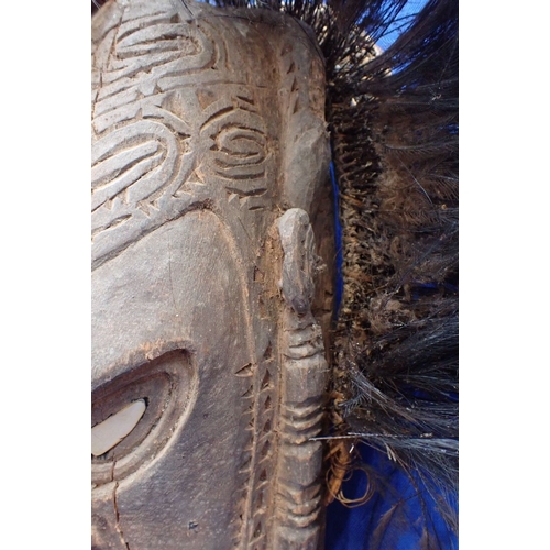 136 - A TRIBAL WOODEN MASK Papua New Guinea, inlaid shell eyes, shell fringe beard and cassawary feather d... 