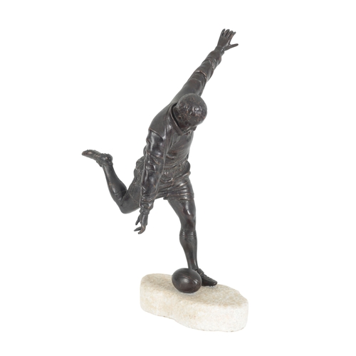 121 - A LARGE BRONZE MODEL OF A RUGBY PLAYER in kicking pose, standing on a rough-hewn marble base, 51cm h... 