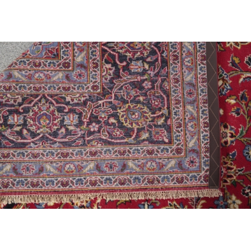 174 - A CENTRAL PERSIAN KASHAN CARPET woven in shades of green and blue, pink, yellow and other colours wi... 