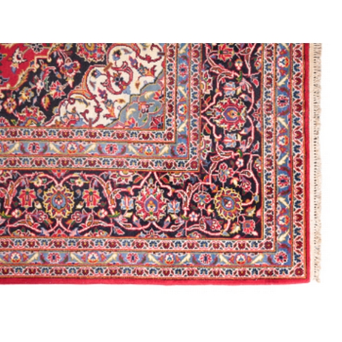 174 - A CENTRAL PERSIAN KASHAN CARPET woven in shades of green and blue, pink, yellow and other colours wi... 