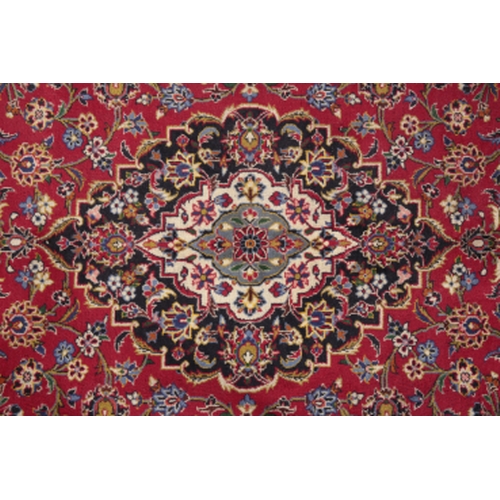 174 - A CENTRAL PERSIAN KASHAN CARPET woven in shades of green and blue, pink, yellow and other colours wi... 