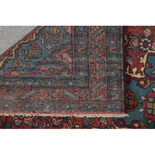 181 - A NORTH WEST PERSIAN MALAYER RUG woven in blue, green and orange with central cruciform medallion an... 