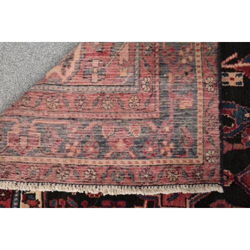 189 - A NORTH WEST PERSIAN NAHAWAND CARPET woven in blue, tan and red with double headed lozenge medallion... 