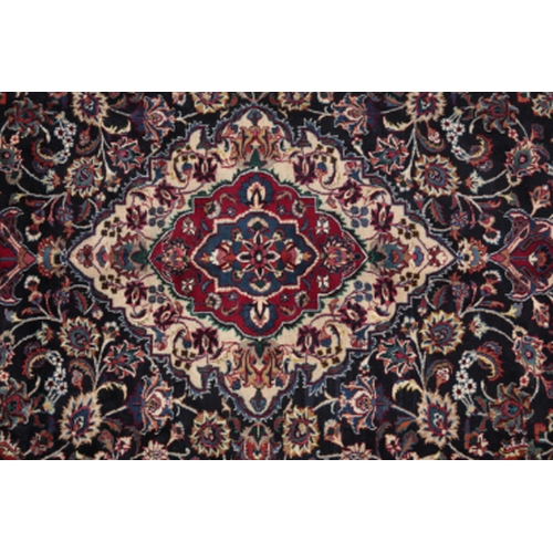 194 - A NORTH EAST PERSIAN MESHED CARPET woven in blue, red, tan and other colours with oval double headed... 