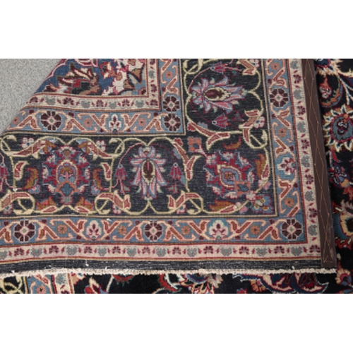 194 - A NORTH EAST PERSIAN MESHED CARPET woven in blue, red, tan and other colours with oval double headed... 