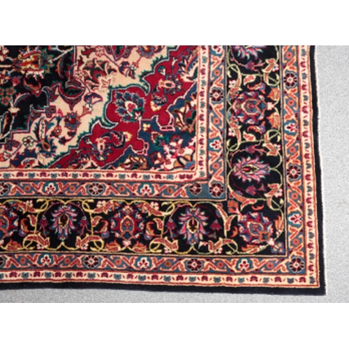 194 - A NORTH EAST PERSIAN MESHED CARPET woven in blue, red, tan and other colours with oval double headed... 