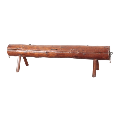 205 - A TREATED PINE GARDEN BENCH 20th century, in the form of a large split log, with cast iron hinges th... 