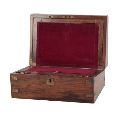 216 - A 19TH CENTURY GRAINED WOOD AND BRASS MOUNTED WRITING BOX the hinged lid opening to an inset writing... 