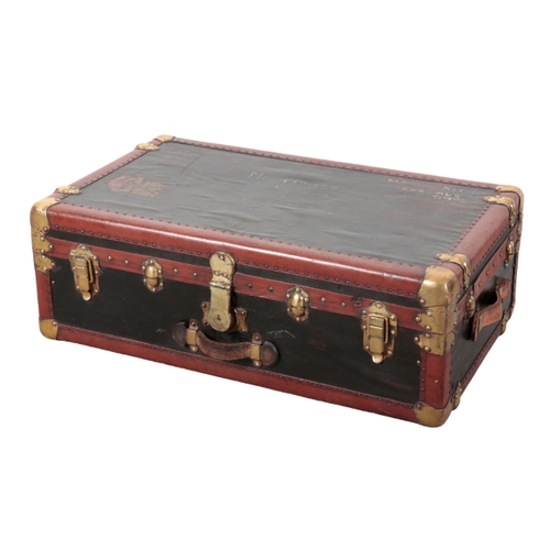 74 - A FRENCH VELLUM BRASS AND WOOD-BOUND TRUNK early 20th century, with brass locks and leather carrying... 