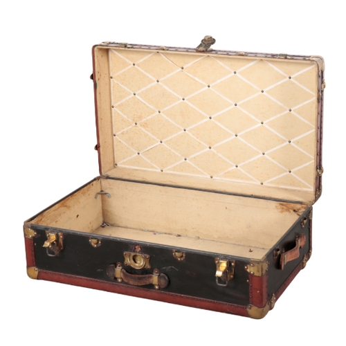 74 - A FRENCH VELLUM BRASS AND WOOD-BOUND TRUNK early 20th century, with brass locks and leather carrying... 