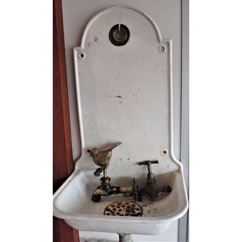 11 - A CONTINENTAL ENAMELLED IRON WALL-MOUNTED WASH BASIN with integral splashback, drain grille, hole fo... 