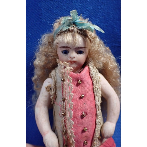 135 - A JOINTED BISQUE DOLL WITH MOVING EYES and original clothing, 10cm high