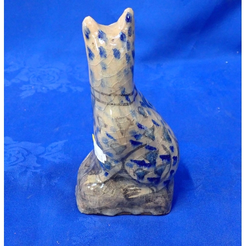 307 - A NAIVELY POTTED PERSIAN POTTERY CAT with remains of old label 17cm high