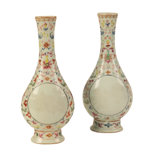 100 - A PAIR OF CHINESE FAMILLE ROSE BOTTLE VASES Qing, painted with formal scrolling lotus and bats aroun... 