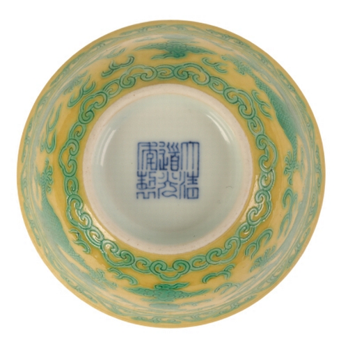 115 - A CHINESE YELLOW-GROUND GREEN ENAMLLED 'DRAGON' BOWL Qing or later, the dragons contesting flaming p... 