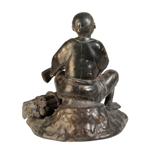 120 - A JAPANESE BRONZE FIGURE OF A MAN Meiji, seated on a rock beside a pile of wood, some gold splashing... 