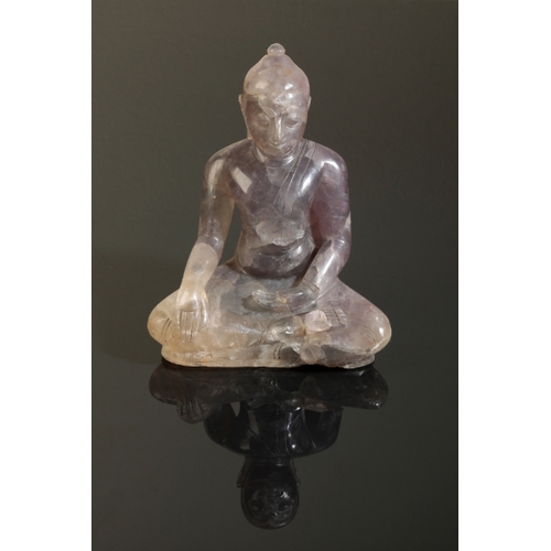 134 - A NEPALESE PINKISH SMOKEY QUARTZ BUDDHA 19th century, seated with legs crossed, 15cm high.