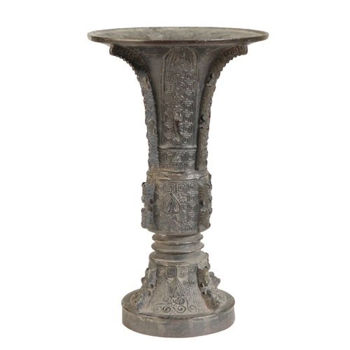 19 - A CHINESE BRONZE GU-SHAPED BEAKER VASE in the archaistic style, cast with flanges and geometric desi... 