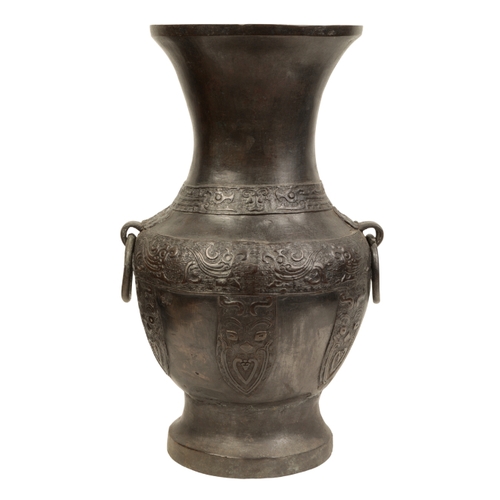 20 - A LARGE CHINESE BRONZE VASE Ming or later, with mask and ring handles, cast with bands of archaic de... 