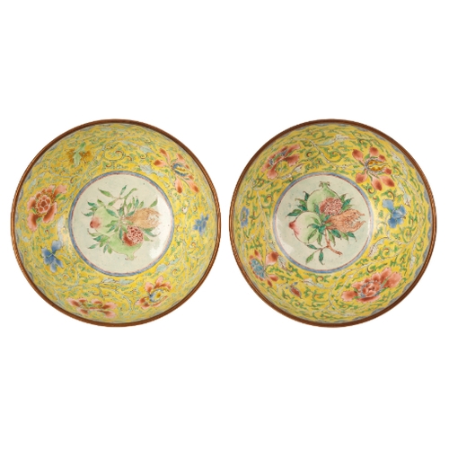 42 - A PAIR OF CHINESE CANTON ENAMEL YELLOW GROUND BOWLS probably early Qing, painted with flowers around... 