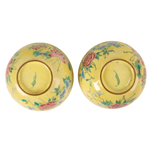 42 - A PAIR OF CHINESE CANTON ENAMEL YELLOW GROUND BOWLS probably early Qing, painted with flowers around... 