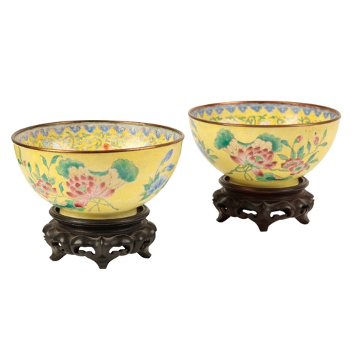 42 - A PAIR OF CHINESE CANTON ENAMEL YELLOW GROUND BOWLS probably early Qing, painted with flowers around... 