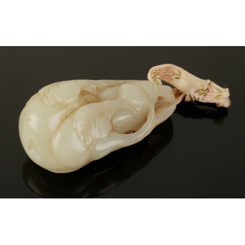 48 - A CHINESE PALE CELADON JADE PENDANT Qing, carved as a gourd with leaves, 6cm long