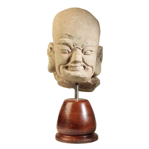 60 - A CHINESE SANDSTONE HEAD OF A LOHAN in the Song dynasty style, 44cm high overall, on a wooden plinth... 