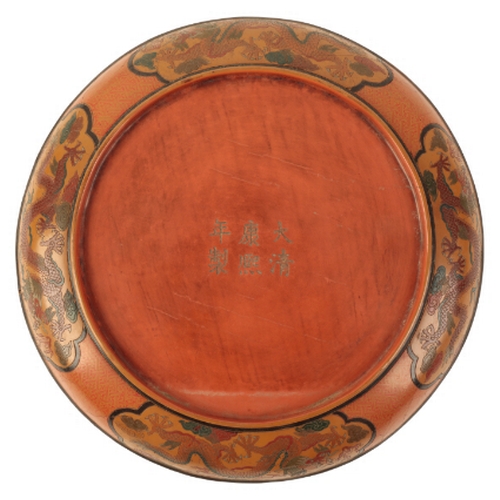 62 - A CHINESE LACQUER DISH decorated in polychrome and incised with a central five-clawed dragon chasing... 