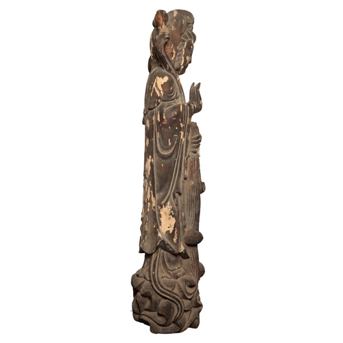 64 - A MONUMENTAL CHINESE LACQUERED WOOD FIGURE OF GUANYIN Qing or later, standing on a wave-scroll base,... 