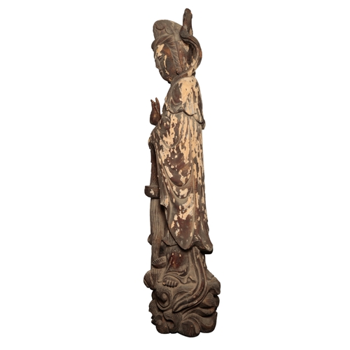 64 - A MONUMENTAL CHINESE LACQUERED WOOD FIGURE OF GUANYIN Qing or later, standing on a wave-scroll base,... 