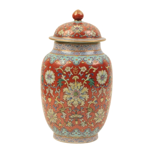 94 - A CHINESE RUBY-GROUND LIDDED JAR enamelled in polychrome with scrolling lotus and fish within formal... 