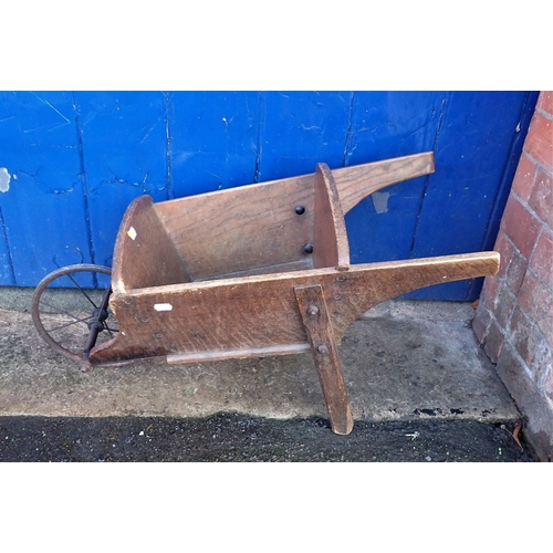 11 - A CHILD'S SIZE OAK WHEELBARROW with metal spoked wheel 75cm long overall