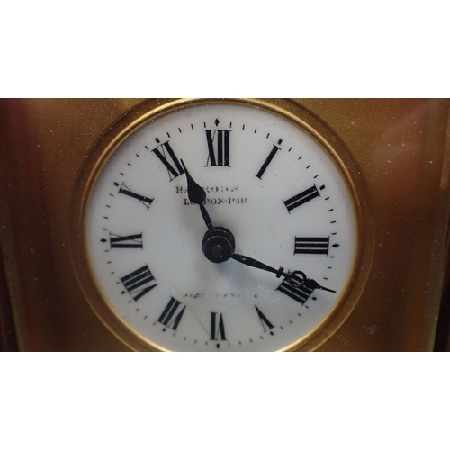 212 - AN EDWARDIAN BRASS CARRIAGE TIMEPIECE RETAILED BY HARRODS 8.5cm high, with key (cracked to dial) and... 